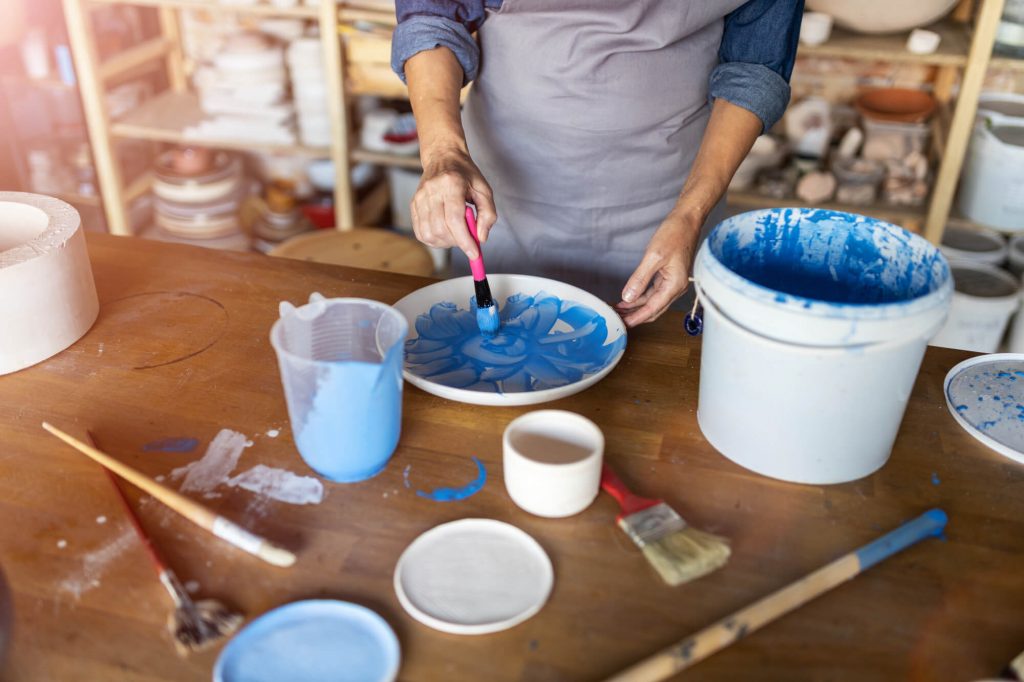 woman mixing blue paint in bowl