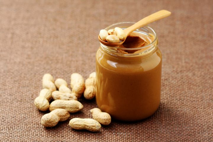 Peanuts with container of peanut butter