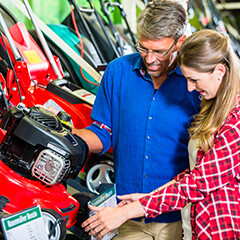 couple looking at lawnmowers in a retail store