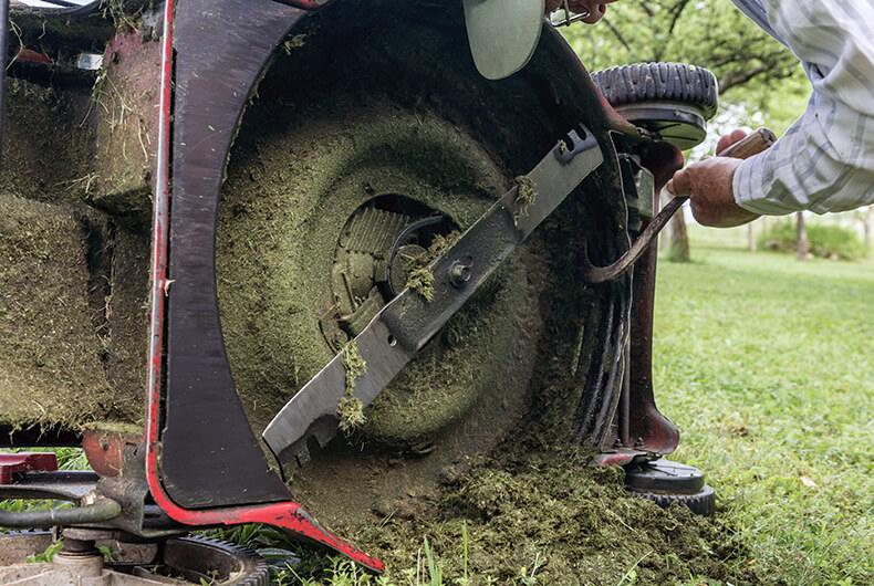 cleaning grass from the lawnmower mowing deck