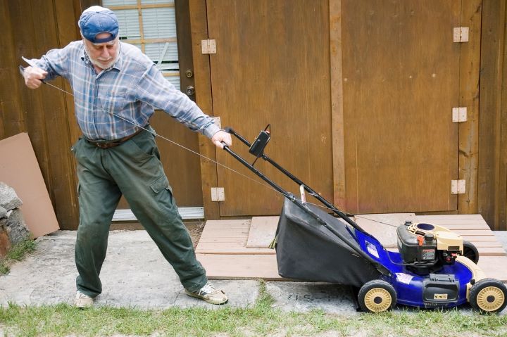 Blue lawnmower in front of door