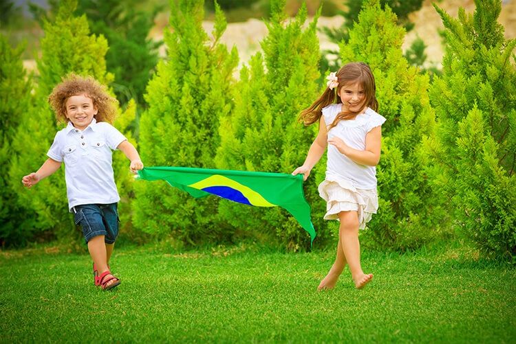 Children running outdoors with a flag