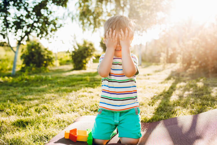 little boy playing hide and go seek