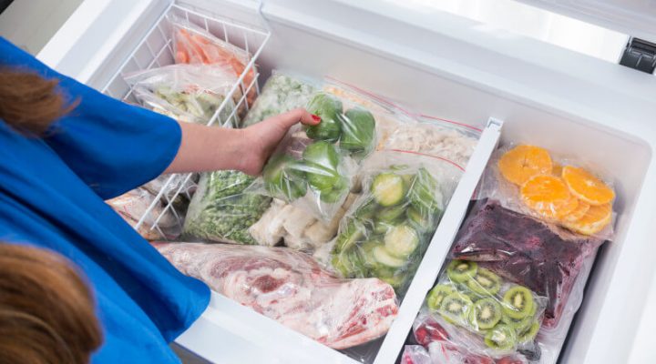 woman getting food out of a stock chest freezer
