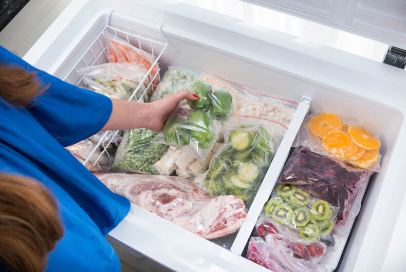 woman getting food out of a stock chest freezer