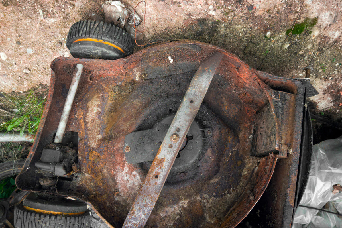 rusty undercarriage of an old lawn mower exposed to the elements