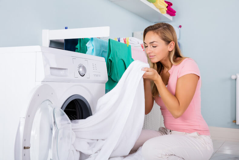 woman drying towels in clothes dryer